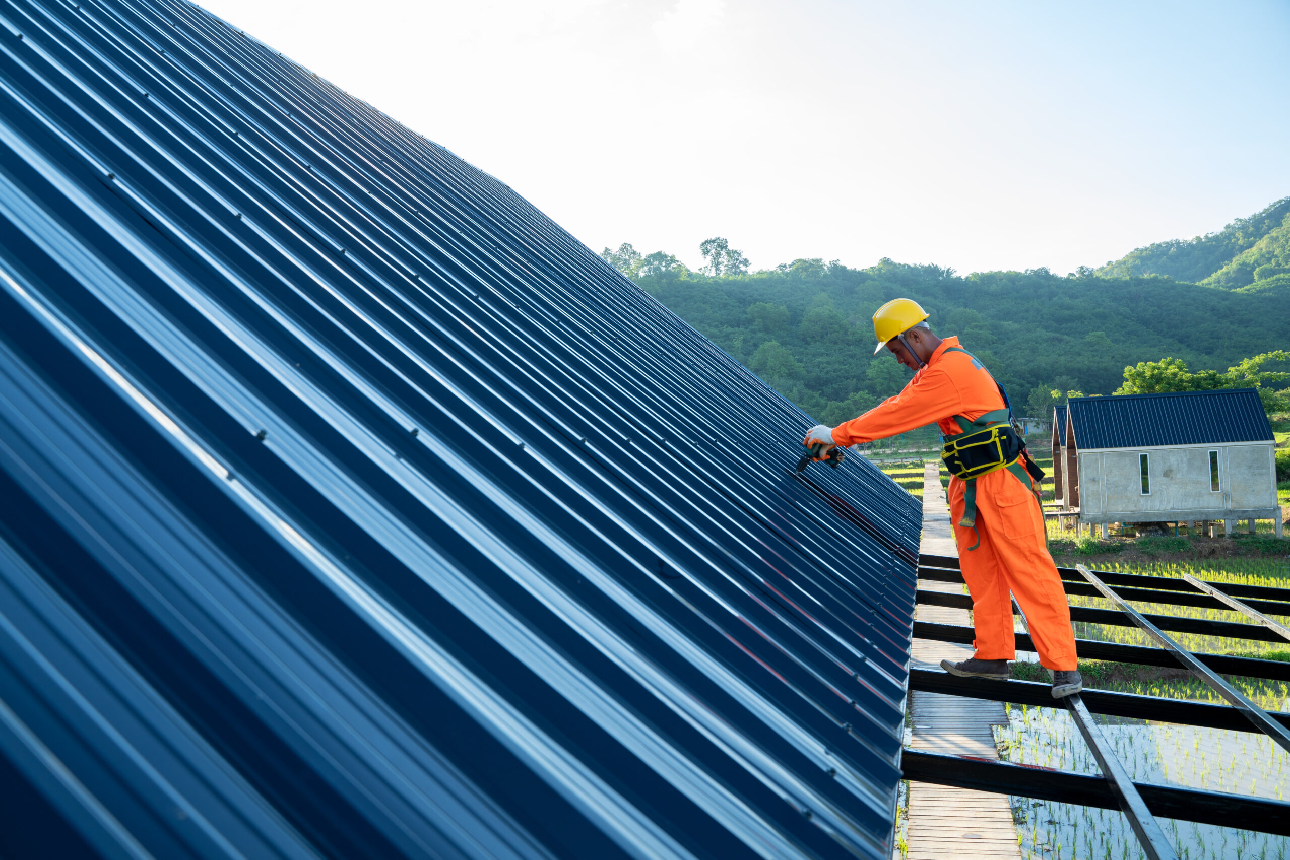 Roofer worker using air or pneumatic nail gun.